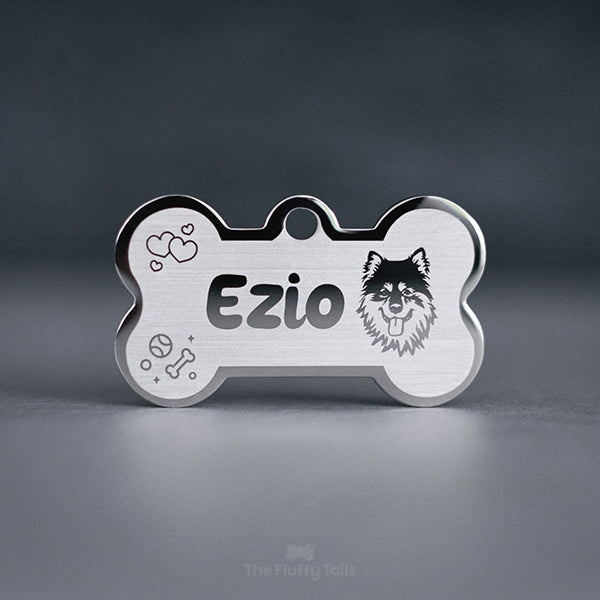 Silvrig namnbricka, ID-bricka i hundbensform med bild på hundrasen finsk lapphund, hjärtan, tennisboll och tuggben