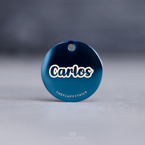 Blå, rund ID-bricka med hundens namn med typsnitt i skrivstil