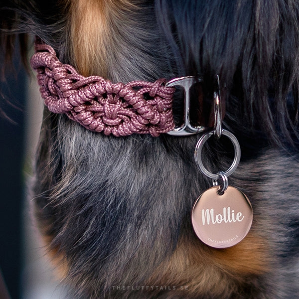 Rosa flätat halsband med en rund, roséfärgad namnbricka med personlig gravyr