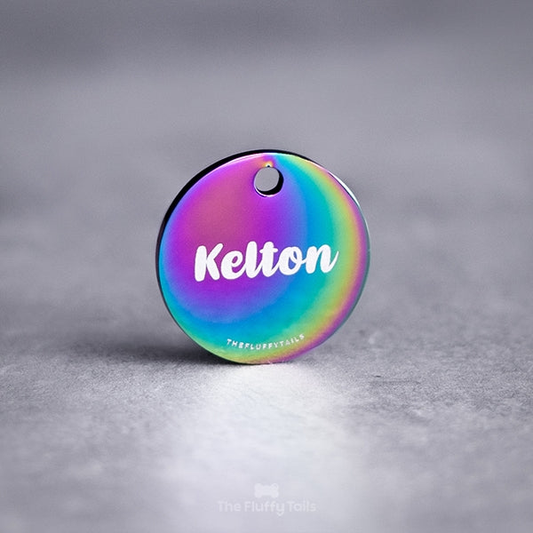Rund, multifärgad namnbricka, id-tag av rostfritt stål i regnbågens olika färger, graverad med djurets namn i skrivstil.