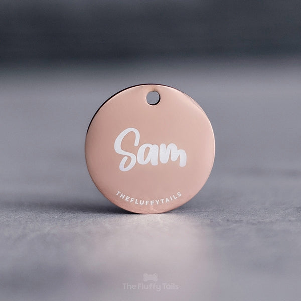 Rund, glänsande ID-bricka i roséguld med hundens namn