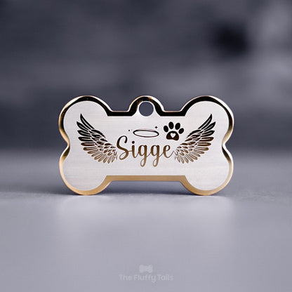 Guldfärgad namnbricka, minnesbricka i hundbensform till minne av hund eller katt, graverad med vingar och tass med ett hjärta