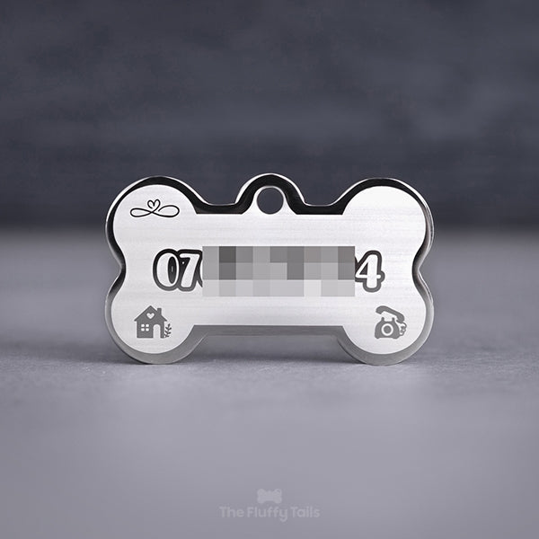 Silvrig, hundbensformad namnbricka med personlig gravyr. Telefonnummer, ikoner av hus, klassisk telefon och evighetssymbol med hjärta