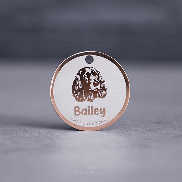 Rund namnbricka av rostfritt stål i färgen roséguld med egen design och personlig gravyr en hundrasen cocker spaniel samt hundens namn