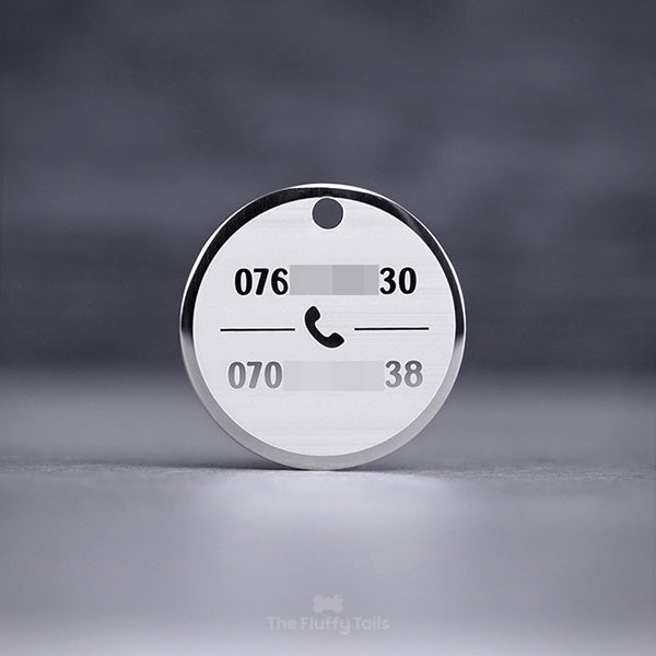 Rund, silvrig namnbricka, ID-bricka för hund och katt med personlig gravyr och egen design, graverad med två telefonnummer och en ikon på en telefon