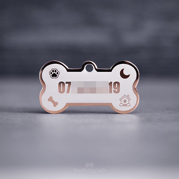 Hundbensformad namnbricka i roséguld med dekorativa ikoner på en tass , måne och ett tuggben samt telefonnummer