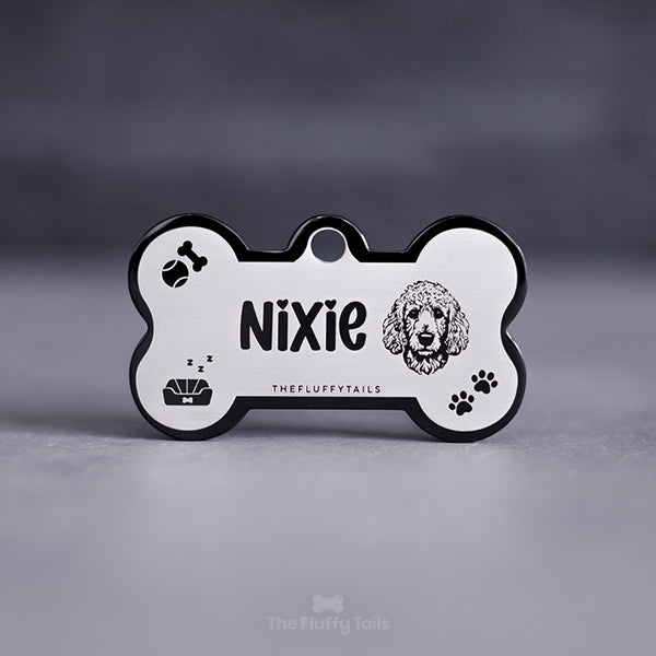 Svart namnbricka, ID-bricka med personlig gravyr och egen design, designad med ikoner av en pudel, tennisboll, tuggben, hundbädd och tassavtryck.