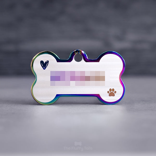 Hundbensformad flerfärgad namnbricka i regnbågens färger, graverad med telefonnummer, ikoner av ett handritat hjärta och en tass. Namnbrickan passar även katter. 