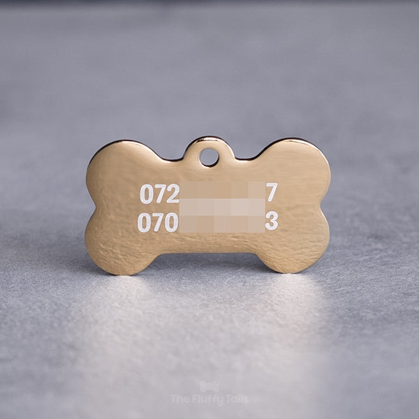 Hundbensformad guldig namnbricka, graverad med två telefonnummer
