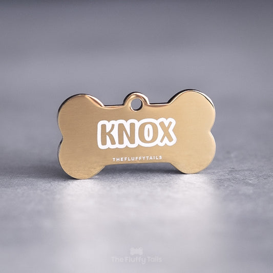 Hundbensformad guldig ID-bricka, av rostfritt stål, graverad med namn i enkel kontur