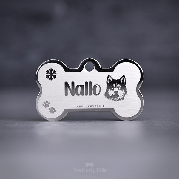 Silvrig namnbricka för hund med personlig gravyr av namn, ikon av hundrasen alaskan husky, snöflinga och tassavtryck.