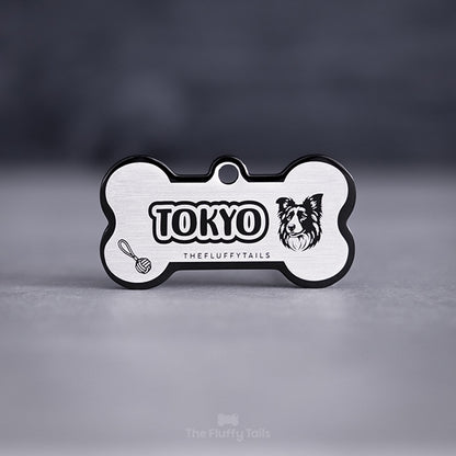 Svart hundbensformad namnbricka av rostfritt stål, graverad med hundens namn, en border collie och repboll