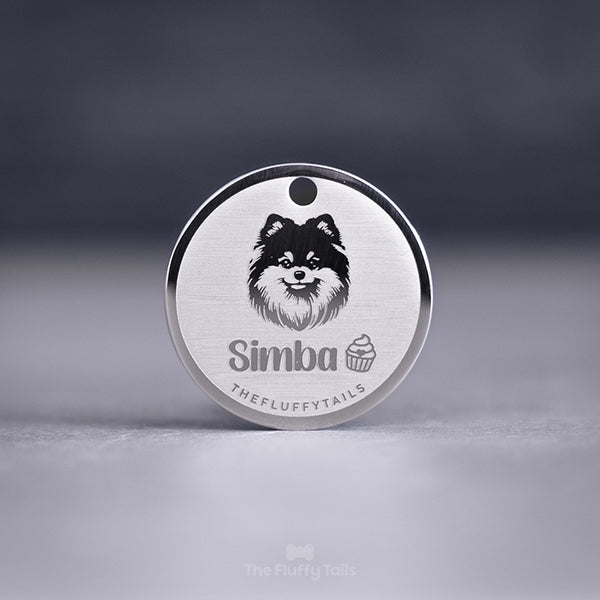 Silvrig rund namnbricka, graverad med en pomeranian, cupcake och hundens namn. Tillverkad av rostfritt stål med spegel polering och personlig gravyr