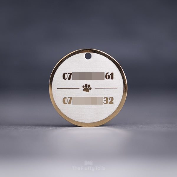 Rund, guldig namnbricka av rostfritt stål, graverad med två telefonnummer till hundägarna och en tass i mitten, passar hund och katt