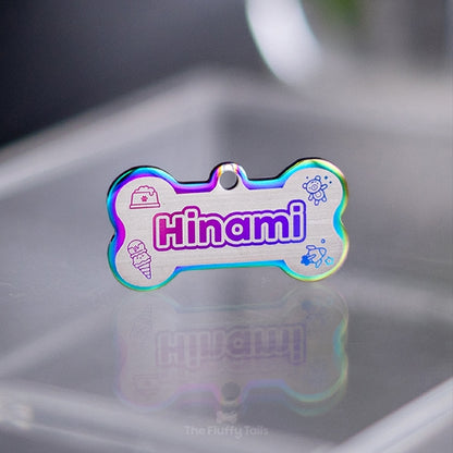 Hundbensformad namnbricka för hund och katt, i regnbågens olika färger med söta, dekorativa ikoner av nalle, glass, rymdraket och fylld hundmatskål