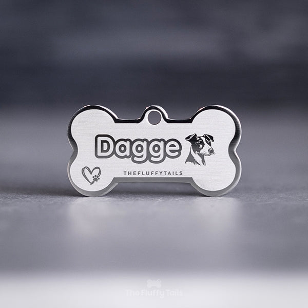 Silvrig, hundbensformad namnbricka med egen design, graverad med en jack russel och ett hjärta med en tass inuti. 