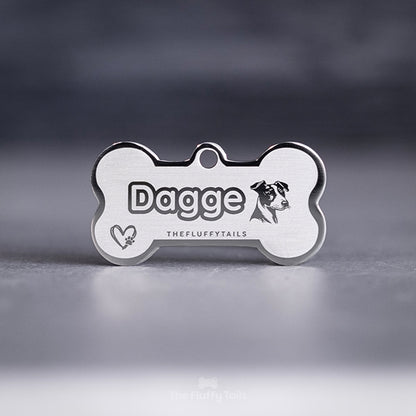 Silvrig, hundbensformad namnbricka med egen design, graverad med en jack russel och ett hjärta med en tass inuti. 