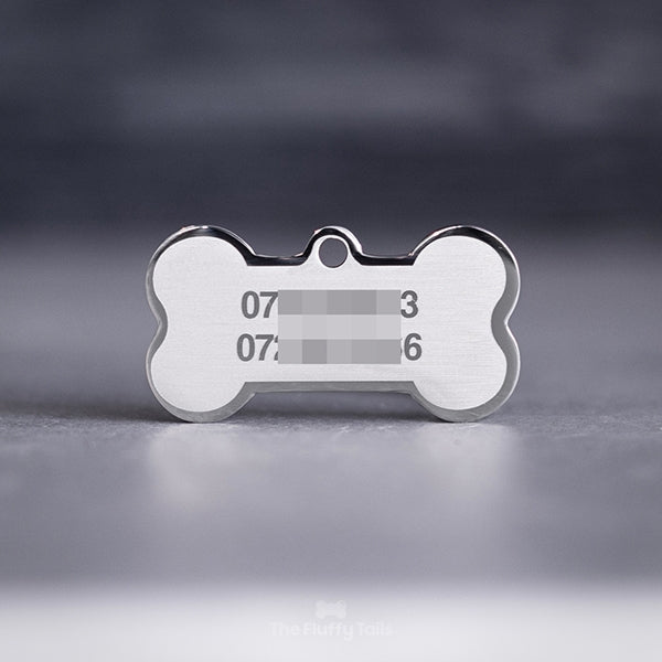 Silvrig, hundbensformad namnbricka av rostfritt stål, graverad med djurägarens telefonnummer.