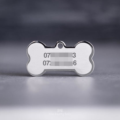 Silvrig, hundbensformad namnbricka av rostfritt stål, graverad med djurägarens telefonnummer.