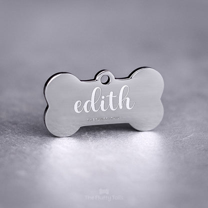 Silvrig hundbensformad ID-bricka, namntag för hund och katt, av rostfritt stål med spegelpolering. Graverad med djurets namn i skrivstil.