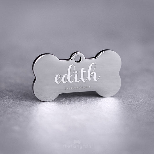 Silvrig hundbensformad ID-bricka, namntag för hund och katt, av rostfritt stål med spegelpolering. Graverad med djurets namn i skrivstil.