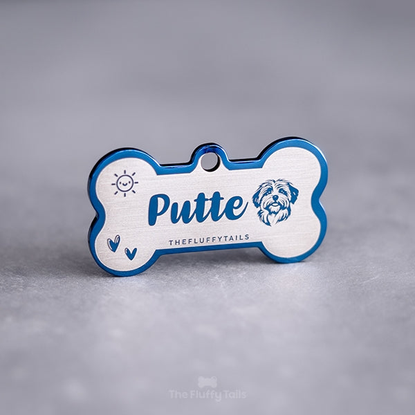 Blå, hundbensformad namnbricka av högkvalitativ rostfritt stål med spegelpolering, graverad med hundens namn, hjärtan, sol och en bild av hundrasen bichon havanais 