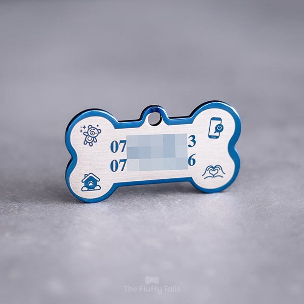 Blå, hundbensformad namnbricka av rostfritt stål med spegelpolering , graverad med två telefonnummer och ikoner av nallebjörn, telefon, hus och handhjärta.