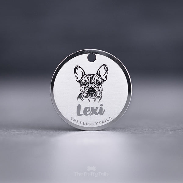 Rund, silvrig namnbricka av rostfritt stål, graverad med egen design. I mitten på brickan är det ett motiv av hundrasen fransk bulldog samt hundens namn undertill.