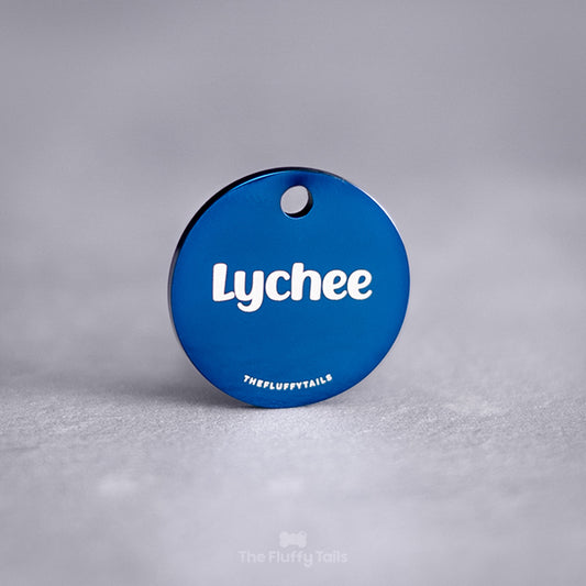 Blå, rund namnbricka av rostfritt stål med personlig gravyr. ID-brickan graveras med djurets namn och passar både hund och katt.