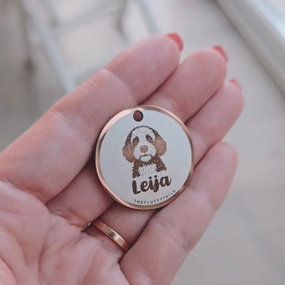 Video som visar en rund roséguldfärgad namnbricka med ikon av spansk vattenhund och hundens namn i skrivstål. Namnbrickan vinklas i ljuset för att visa dess spegelblanka yta och reflektioner.